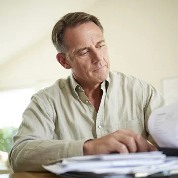 мужчина сидит за столом и изучает бумаги