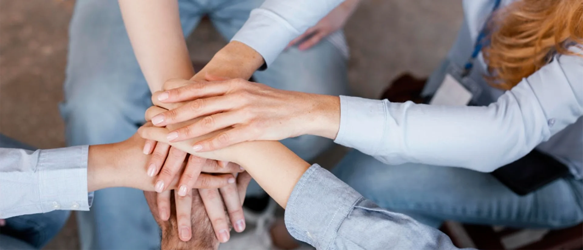 Группа людей положили свои ладони друг на друга